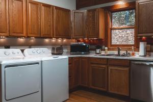 a kitchen with white appliances and wooden cabinets at Deer Run Cabin at 36 North - Hot Tub in Purlear