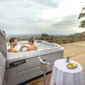 a man and woman in a bath tub on a deck at Vilafoia in Monchique