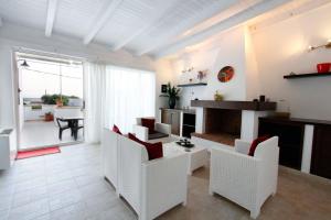 ein Wohnzimmer mit weißen Stühlen und einem Tisch in der Unterkunft Villa Lata in Marina San Gregorio