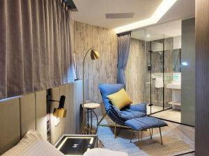 a room with a blue chair and a bathroom at 品悅文旅-免費停車場免費特斯拉充電近東大門夜市 in Hualien City +122 photos