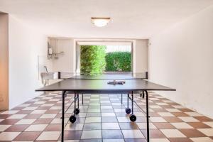 una mesa de ping pong en una habitación con ventana en Villa Carini with 3000 mq garden & heated pool, en Castelnuovo del Garda