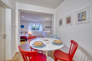 jadalnia z białym stołem i czerwonymi krzesłami w obiekcie Centrally located apartment with parking space w mieście Caldaro +4 zdjęcia