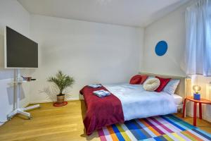 1 dormitorio con 1 cama y TV. en Centrally located apartment with parking space en Caldaro