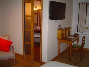 a room with a desk and a table with a television at Oudoty in Kerlouan