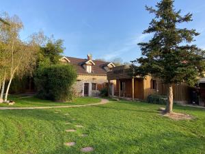 a house with a tree in the yard at Les Crinieres En Brie in Saint-Ouen-en-Brie