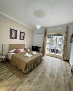 a bedroom with a bed and a large window at A boné Guest house in Catania