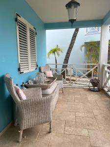 a living room with chairs and a blue wall at Kas Lagoen Blou (Ocean Breeze 13) in Kralendijk