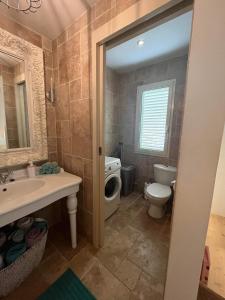 a bathroom with a toilet and a sink and a mirror at Kas Lagoen Blou (Ocean Breeze 13) in Kralendijk