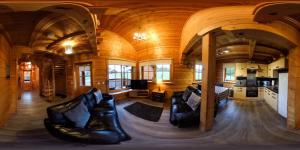 una sala de estar con muebles de cuero en una casa de madera en Norwegian Log Cabin The Roe Deer -sauna & hot tub, en Keith