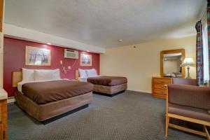 Habitación de hotel con 2 camas y espejo en Classic Inn, en Saco
