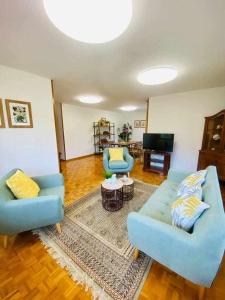Leorio的住宿－La FayonaRelax y desconexión al lado de Gijon，客厅配有2张蓝色沙发和1台电视
