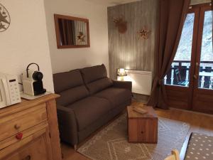 een woonkamer met een bank en een tafel bij La Couette in Le Grand-Bornand