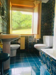a bathroom with two toilets and a sink and a window at La FayonaRelax y desconexión al lado de Gijon in Leorio