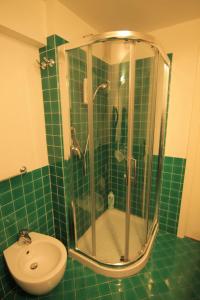 a green tiled bathroom with a shower and a sink at Fabrizi79 in Pescara