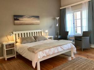 1 dormitorio con 1 cama blanca grande en una habitación en The Secret Garden Guesthouse en Swakopmund