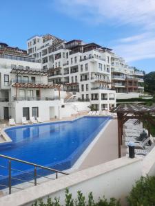 ein großer Pool vor einigen Gebäuden in der Unterkunft Byala Vista Cliff Apartments in Byala