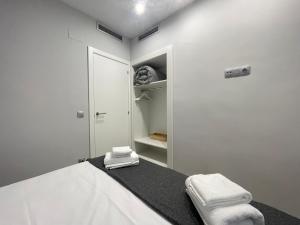 Schlafzimmer mit einem Bett mit weißer Bettwäsche und Handtüchern in der Unterkunft Apartaments Voramar Roses in Roses