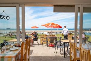Anchor Guest House في هافرفوردوست: فناء به طاولات والناس جالسين على الشاطئ