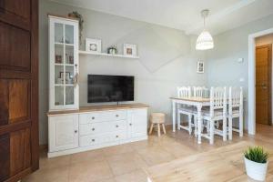 sala de estar con TV y mesa de comedor en Balcón Indiano, en Colombres