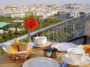 einen Tisch mit Tellern aus Essen auf einem Balkon in der Unterkunft SANA Rex Hotel in Lissabon