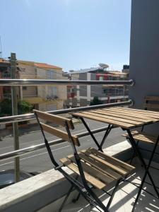 um banco de madeira sentado em cima de uma varanda em Urban Aparthotel em Praia