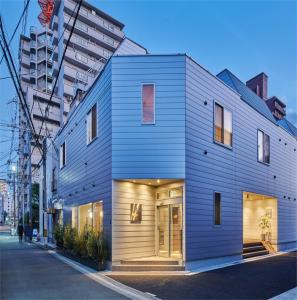 uma casa azul ao lado de uma rua em 俪居花园酒店Reikyo Garden Hotel em Osaka