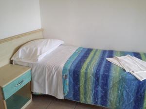 a small bedroom with a bed and a night stand at Residence lido adriano in Lido Adriano