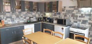 バート・ザクサにあるGruppenhaus bis 14 Personen im Südharzの青いキャビネットとテーブルと椅子のあるキッチン
