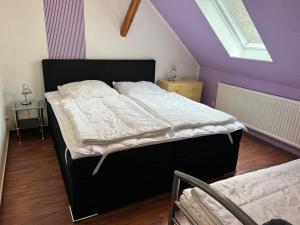 バート・ザクサにあるGruppenhaus bis 14 Personen im Südharzの紫の壁のベッドルーム1室(ベッド1台付)
