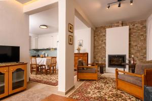 a living room with a tv and a fireplace at Kyra’s House in Neraïdochóri +10 photos
