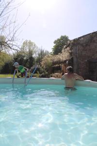 two people in a swimming pool with water skiing at Le Refuge aux étoiles in Saint-Antonin