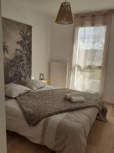 um quarto com uma cama grande e uma janela em Maison au Moustoir-Arradon à 200 m du Golfe em Arradon