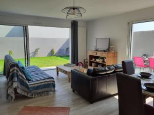 uma sala de estar com um sofá e cadeiras e uma televisão em Maison au Moustoir-Arradon à 200 m du Golfe em Arradon