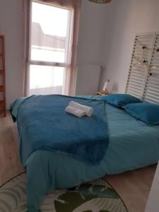uma cama azul com duas toalhas em cima em Maison au Moustoir-Arradon à 200 m du Golfe em Arradon