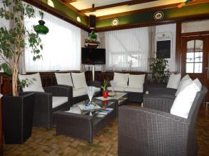uma sala de estar com cadeiras de vime e uma mesa em Hotel Jägersruh em Monschau
