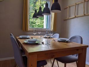 uma mesa de madeira com cadeiras e copos de vinho em Schmugglernest em Monschau