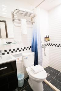 y baño con aseo blanco y lavamanos. en HotelsHere - Ximen en Taipéi