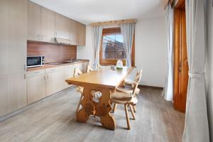 cocina con mesa de madera y sillas en Appartamento Vacanze Matteo, en Livigno