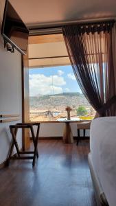 uma sala de estar com uma grande janela com vista em Casa Esmeralda by Katari em Cusco