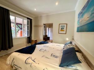a bedroom with a bed with blue pillows on it at The Secret Garden Guesthouse in Swakopmund