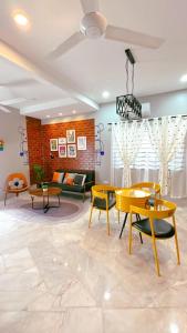 a living room with yellow tables and chairs at Bonjour Homestay in Sungai Pelik