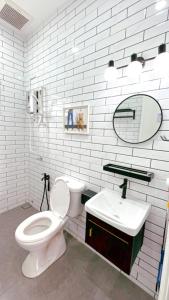 a white bathroom with a toilet and a sink at Bonjour Homestay in Sungai Pelik