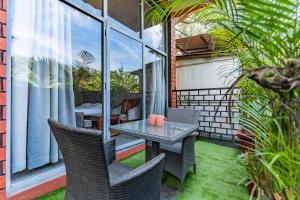 a patio with a table and chairs on a balcony at Zense Candolim in Candolim