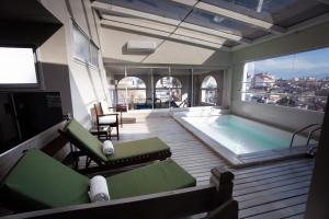 a room with a pool and chairs and a large window at Hotel Almería in Salta