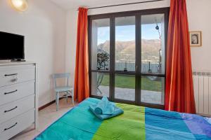 a bedroom with a bed and a window with a view at Ampia vista sul lago di Como in Bellano