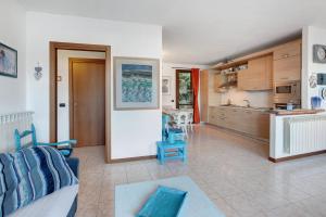 a living room with a couch and a kitchen at Ampia vista sul lago di Como in Bellano