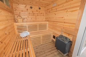 a wooden sauna with a bench and a trash can at Pure relaxation at it's finest, offering moments of harmony and tranquillity - Sauna & Hot tub in Shanklin