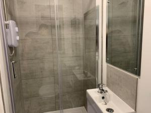 uma casa de banho com um chuveiro, um lavatório e um WC. em 1. Delightful Apartment em Birmingham