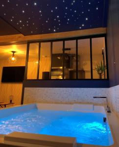 una grande vasca blu in una stanza di L'Eclipse maison romantique avec Jacuzzi 