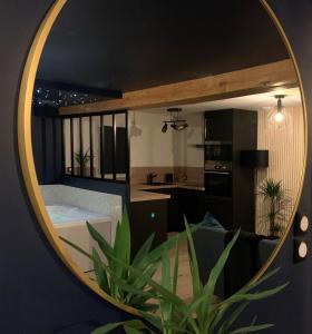 specchio che riflette un bagno con vasca in una stanza di L'Eclipse maison romantique avec Jacuzzi 